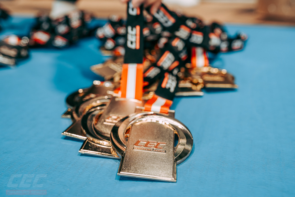 CEC medals face up on the mat, the stamped faces and branded ribbons together