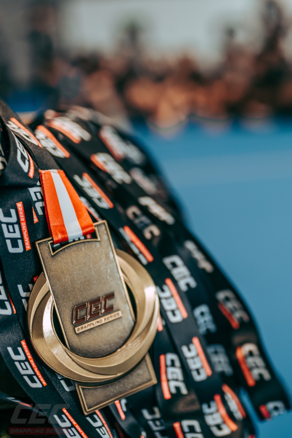 Close-up of a CEC medal — the wordmark stamped into the face, on a CEC-branded ribbon